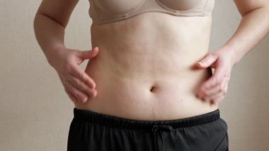 Tanınmayan bir kadın karnını şişmanlatıyor.