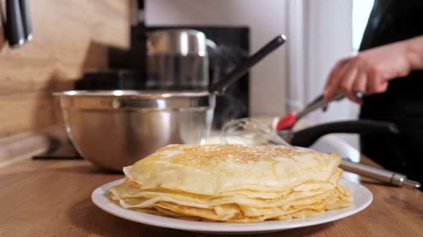 Unrecognizable woman puts a ready-made pancake with a spatula in a stack, slow motion — Stock Video