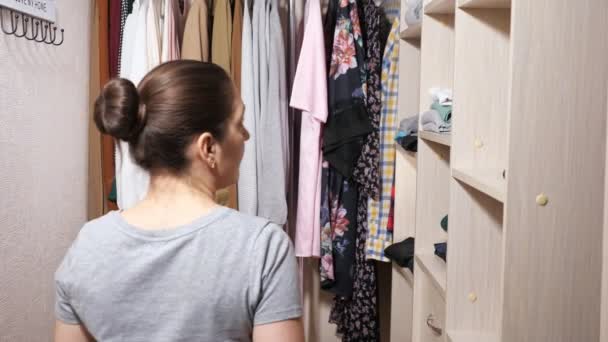 Wanita menyembunyikan celengan di rak dalam lemari berjalan yang luas — Stok Video