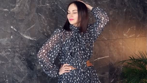 Short haired brunette in polka dot dress with brown belt — Stock Video