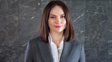 Kısa siyah saçlı, gülümseyen ve baş parmağını kaldıran genç bir kadın.