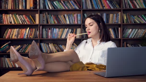 Sexy mujer de negocios en blusa y falda pone piernas en la mesa — Vídeos de Stock