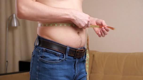 Unrecognizable man measures waist with a tape — Αρχείο Βίντεο