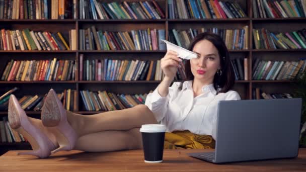 Joyful secretary in blouse and skirt plays with paper plane — Stock Video