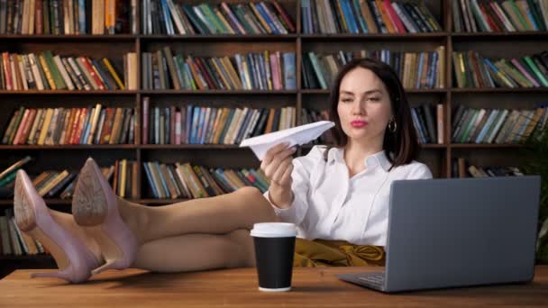 Joyful secretary in blouse and skirt plays with paper plane — Stock Video