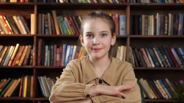 Schoolgirl in brown jacket waves hand talks and smiles — Stock Video