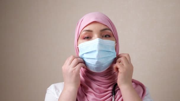 Mulher médico endireita hijab e máscara médica — Vídeo de Stock