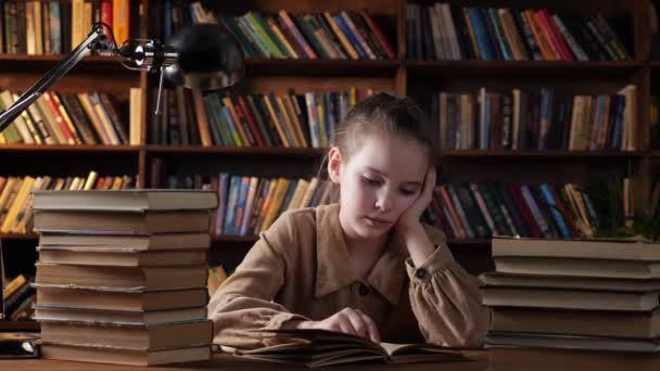 茶色のジャケットの若い女性は本の中で教材を読みます — ストック動画