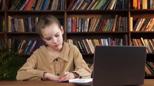 Junge Studentin in brauner Jacke schreibt Vorlesung in Notizbuch — Stockvideo