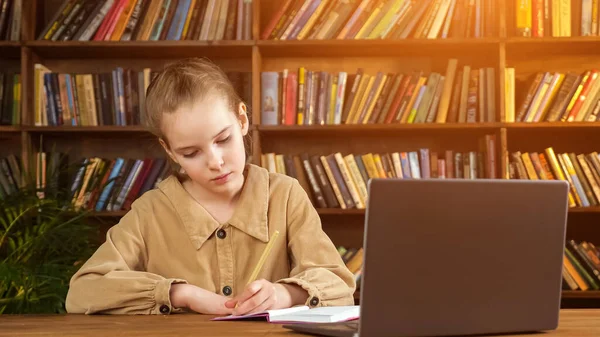 Ung student i brun jacka skriver föreläsning i anteckningsbok — Stockfoto