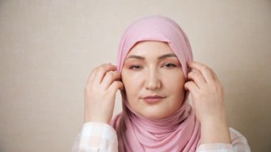 Genç Müslüman kadın başörtüsünü düzeltti ve gülümsedi.