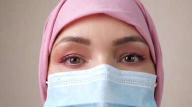 Tıbbi maske takan Müslüman kadının yakın çekimde gözleri.