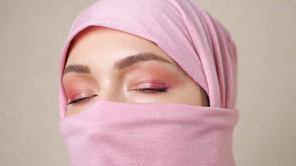 Muselman kvinna i en rosa scarf att bara öppnar ögon — Stockvideo