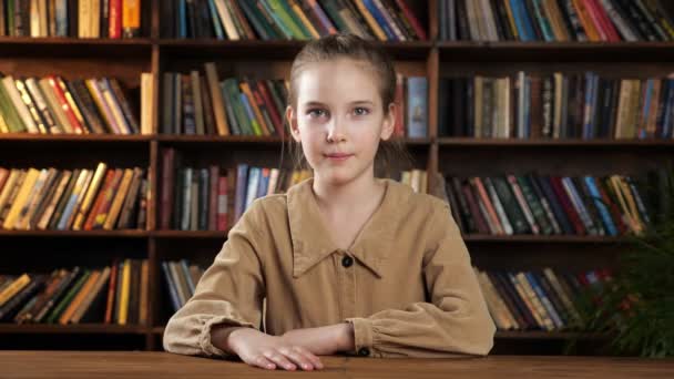 새 갈색 목조 책상에 앉아 있는 여학생 모델 — 비디오