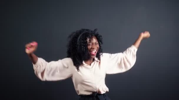 Афроамериканська пані з навушниками на чорному — стокове відео