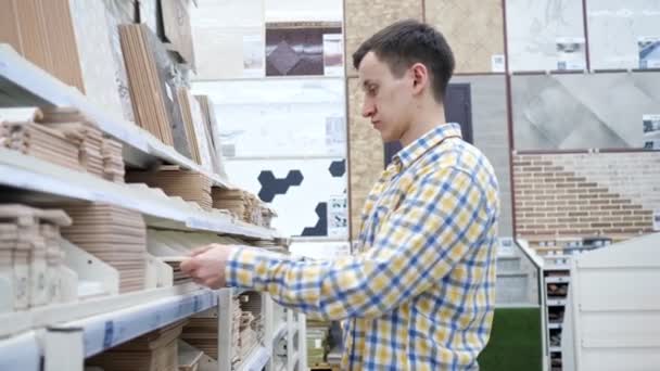 年轻人在五金店选择瓷砖慢动作 — 图库视频影像