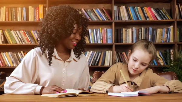 Professional individual tutor dictates text to schoolgirl