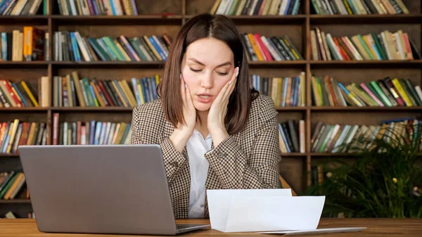 Affärskvinna typer på grå laptop tittar på bankbrev — Stockfoto