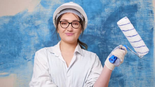 Δημιουργική κυρία χαμογελά στέκεται πίσω νέο τοίχο βαμμένο σε μπλε — Αρχείο Βίντεο