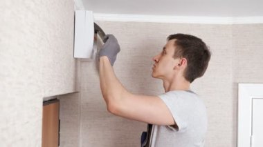 Üniformalı elektrikçi giriş odasındaki santrali kontrol ediyor.