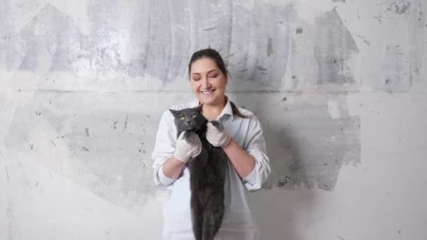 Wanita ceria berambut cokelat dalam tarian kemeja putih memegang kucing besar — Stok Video