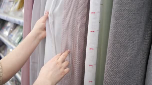 Nerozpoznatelná žena zkoumá tylu a záclony v obchodě — Stock video
