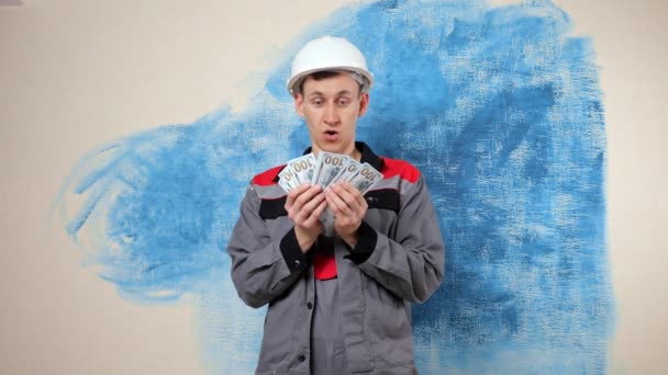 Happy handyman in protective helmet throws up money in air — Stock Video
