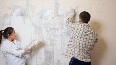 Neşeli çift dans eder ve eski duvar kağıtlarını eğlenceli bir şekilde siler