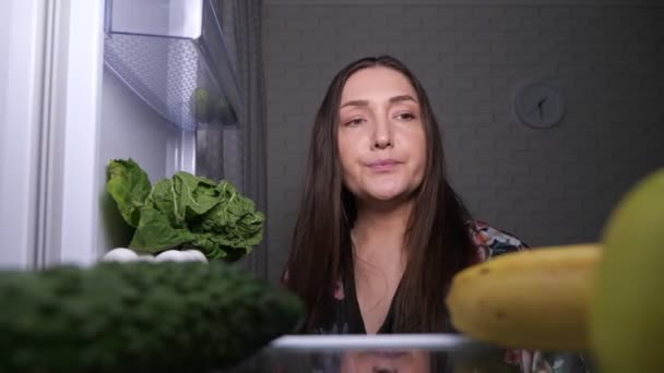 Femme réfléchie cherche des collations et choisit la pomme verte — Video