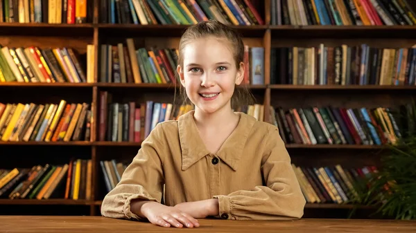 새 갈색 목조 책상에 앉아 있는 여학생 모델 — 스톡 사진