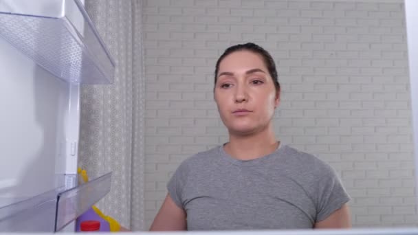 Ibu rumah tangga muda membersihkan rak kulkas dengan kain — Stok Video