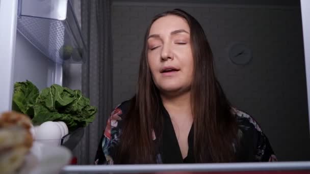 Grappige vrouw kiest komkommer boven heerlijke chocoladetaart — Stockvideo