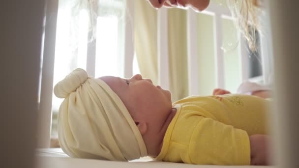 Joyful jovem mãe beija bebê menina em roupas amarelas — Vídeo de Stock