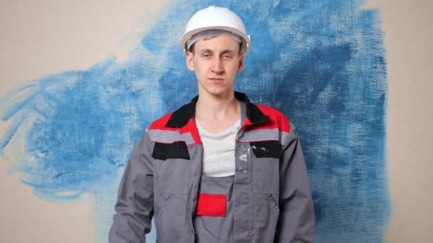 Fröhlicher Reparateur im Helm demonstriert Akkubohrmaschine — Stockvideo