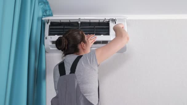 Vrouw trekt schroef met schroevendraaier op airconditioner — Stockvideo