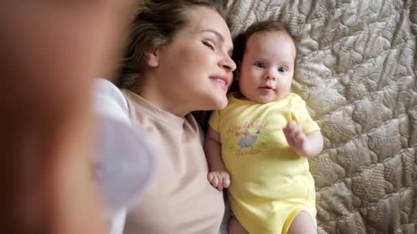 Alegre jovem mãe dá beijo no bebê filha bochecha — Vídeo de Stock