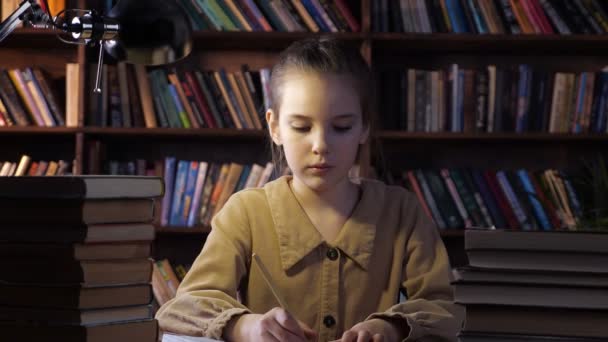 Уставшая молодая леди пишет домашнее задание в блокноте — стоковое видео