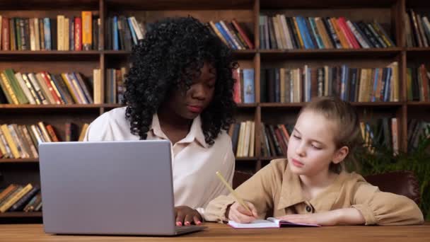 Profesor individual explica el material del estudiante y niña escribe — Vídeo de stock