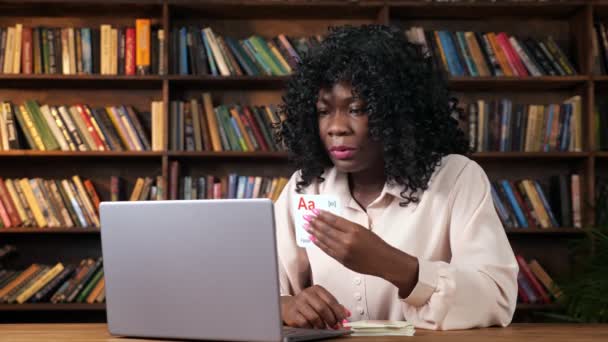 Profesora afroamericana muestra tarjetas con letras a pantalla — Vídeo de stock