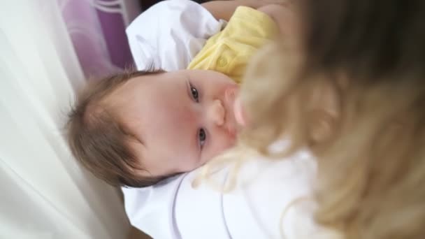 Tânără mamă purtând cămașă albă calmează fetița îngrijorată — Videoclip de stoc