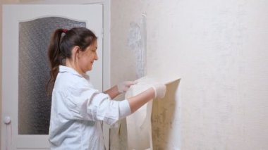 Gülümseyen at kuyruklu daire sahibi eski beyaz duvar kağıtlarını aldı.