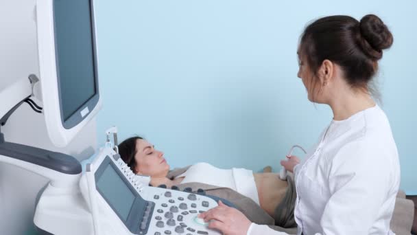Gülümseyen doktor hastanede kadına ultrasonografi yapıyor. — Stok video