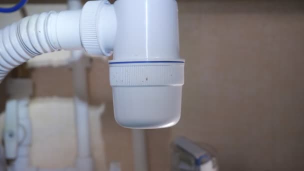 Checking waste trap leakage under sink with flashlight — Stock Video