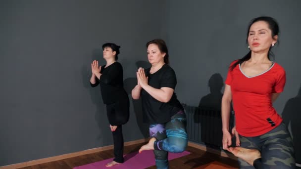 Diferentes personas se paran en posturas de yoga sosteniendo piernas con manos — Vídeos de Stock