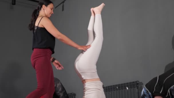 Experienced lady trainer helps woman yoga class participant — Stock video