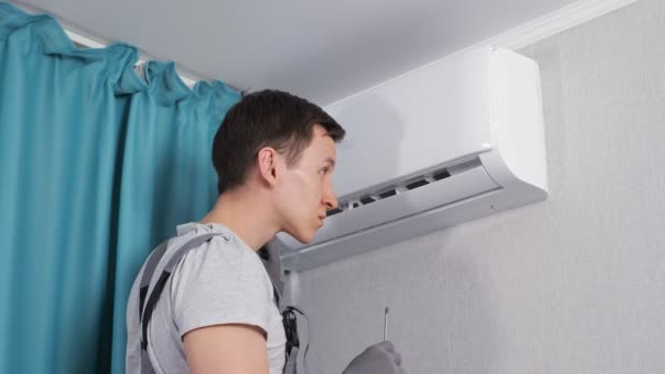 Focused young electrician removes screws near wires block — Stock video