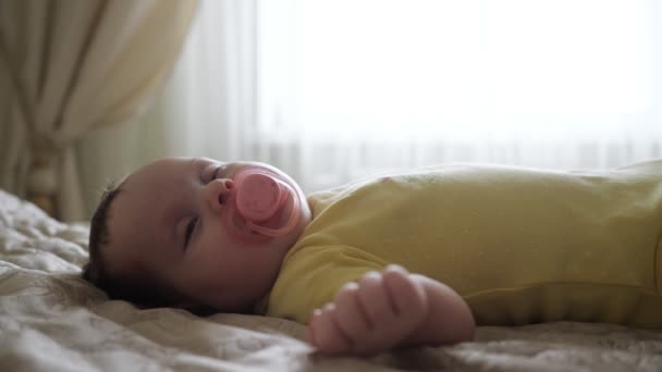 Närbild av en sovande bebis med en napphållare i munnen — Stockvideo