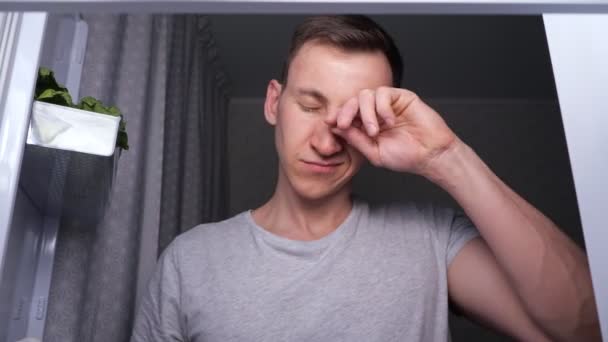 Ospalý muž zívá a bere různé občerstvení z lednice — Stock video