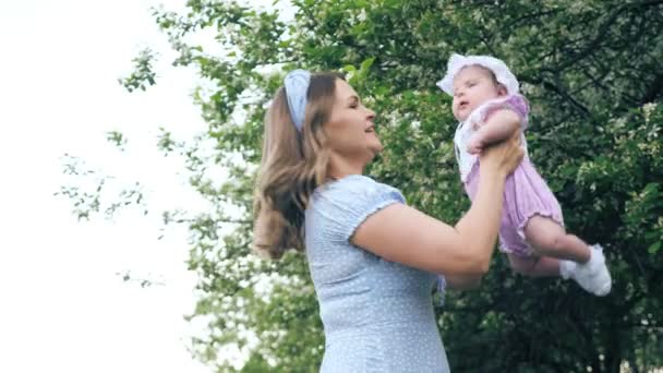Mãe incrível com cabelos claros soltos gira com bebê menina — Vídeo de Stock