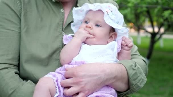 Engraçado bebê menina no chapéu branco segura os dedos na boca chupando — Vídeo de Stock